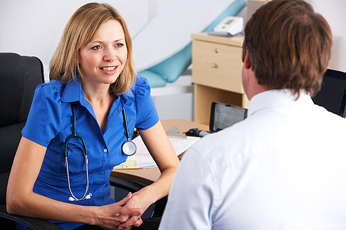 A nurse speaking to a patient.