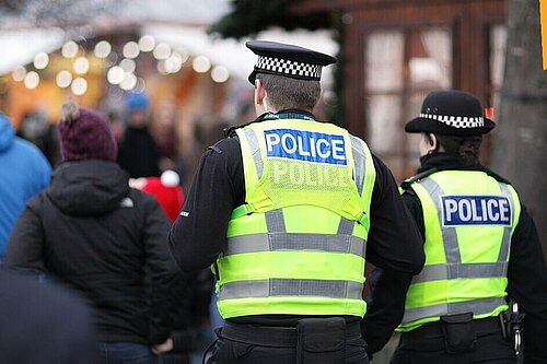 Two police officers walk down a street